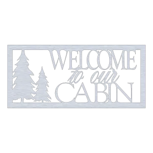 A rectangular wall sign made of aluminum with a brushed finish, featuring the words 'Welcome to Our Cabin' in a mix of script and block letters. To the left, two stylized pine trees are cut out, creating a silhouette effect. The sign has a modern, rustic look and is set against a black background.